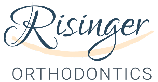 Risinger Orthodontics logo. Navy blue text with a tan brush stroke in between the two words.