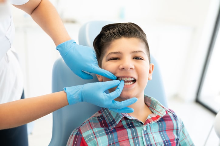 a child with braces getting work done by a dental professional