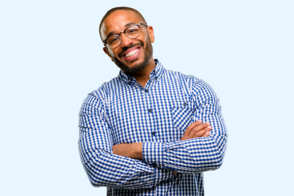 iStock-1041758604 Man with braces in blue button down shirt smiling with his arms crossed