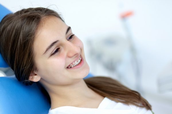 Cute teenage girl smiling with her braces at dentist office Cute teenage girl smiling with her braces at dentist office